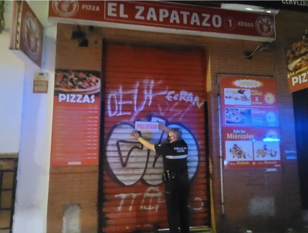 Un agente precinta un establecimiento de alimentación.