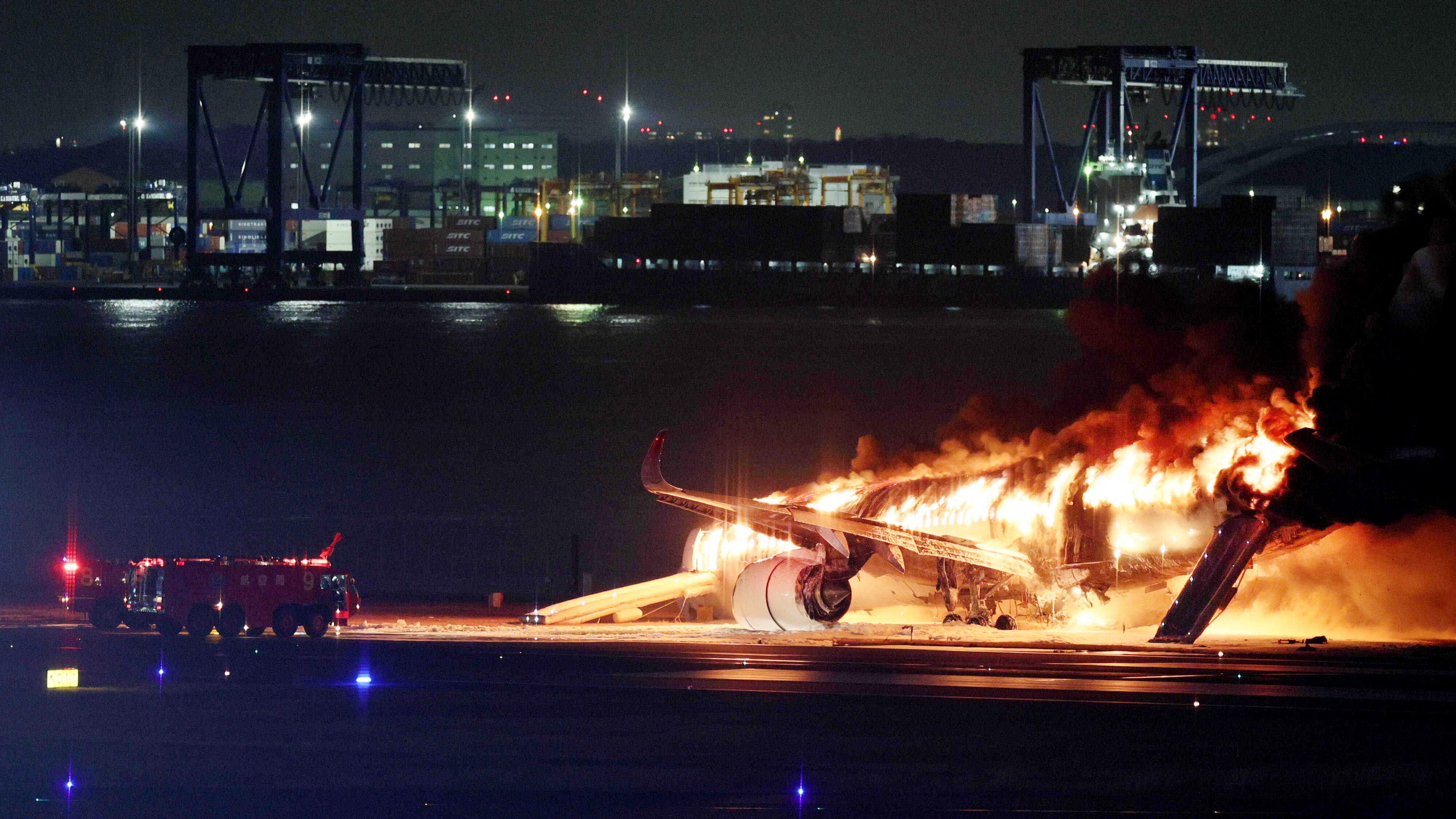 El avión de Japan Airlines envuelto en llamas después del accidente