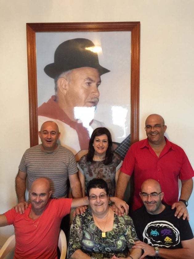 Luis Arráez con sus hermanos y al fondo, la imagen de su padre.