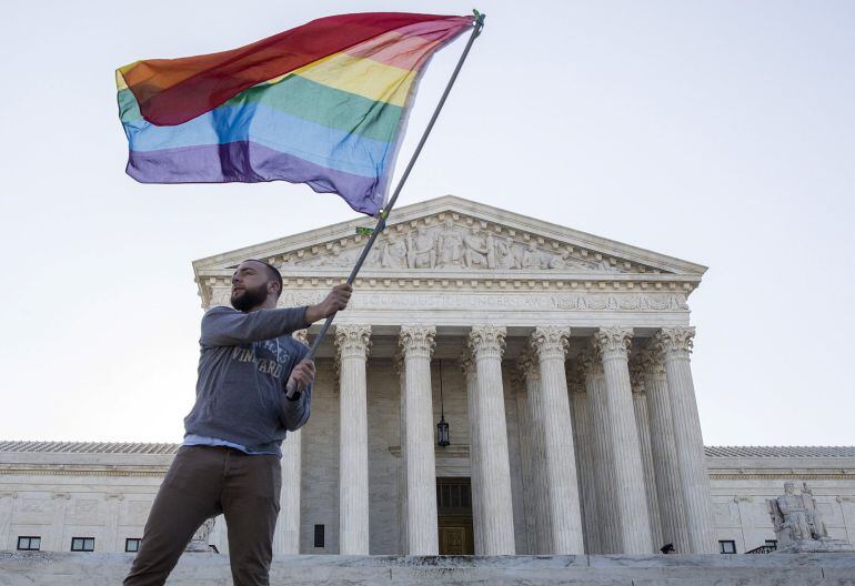 Un hombre ondea la bandera arcoiris ante la Corte Suprema de EEUU