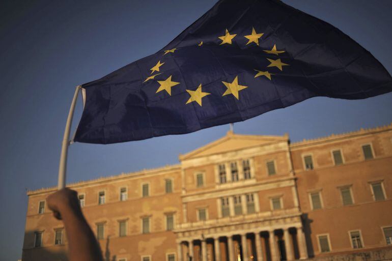 Un manifestante ondea una bandera de la Unión Europea, durante una protesta a favor de la continuación en la zona euro, frente al Parlamento de Atenas, Grecia