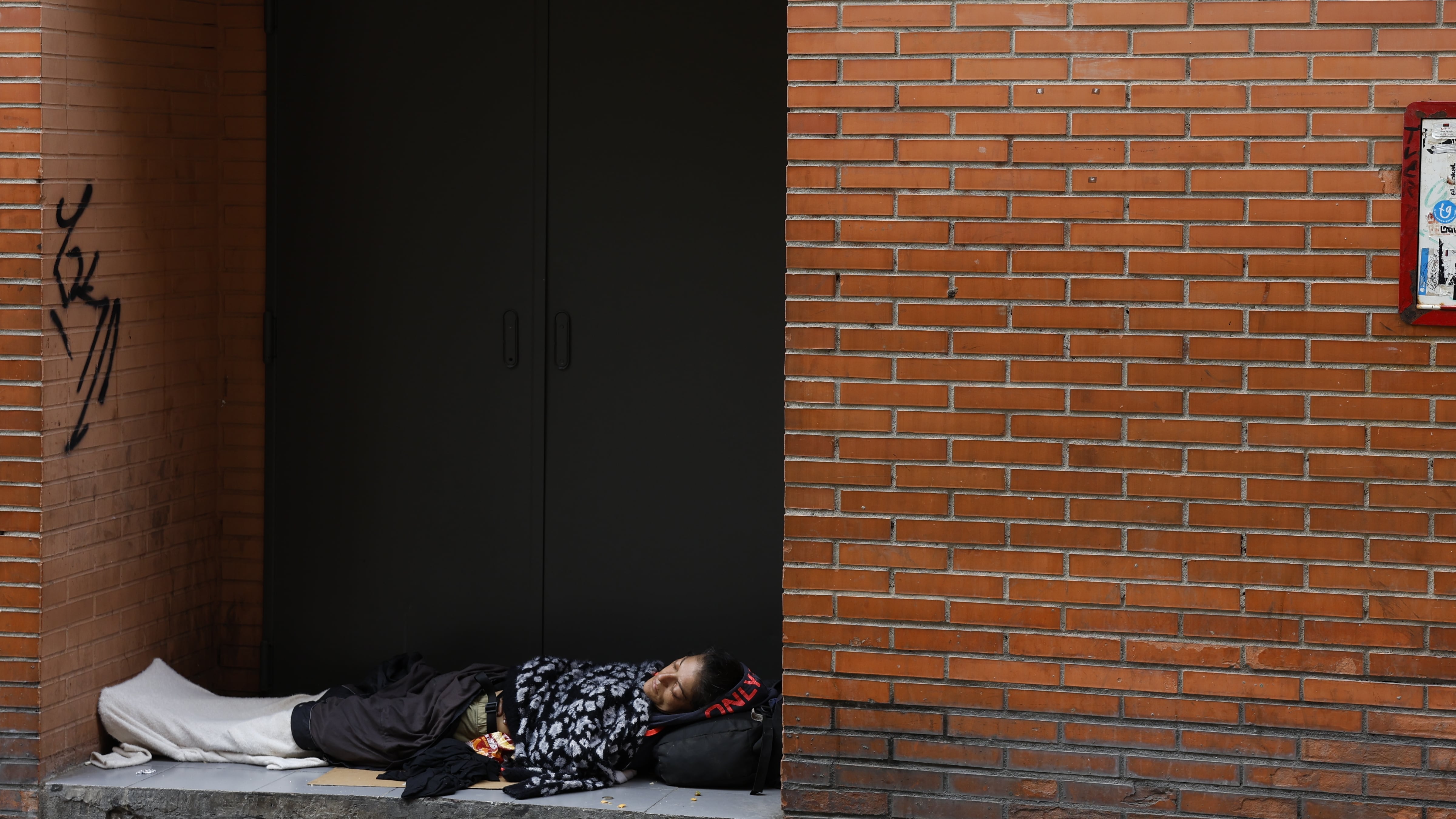 MÁLAGA, 15/10/2024.- Una sintecho acostada en un portal en una calle de Málaga. Un total de 3,2 millones de personas de la población andaluza se encuentra en riesgo de pobreza y/o exclusión social, lo que supone un 37,5 % del total de habitantes de la región, que ocupa el puesto más elevado de todas las comunidades en cuatro de los cinco principales indicadores de pobreza.EFE/Jorge Zapata