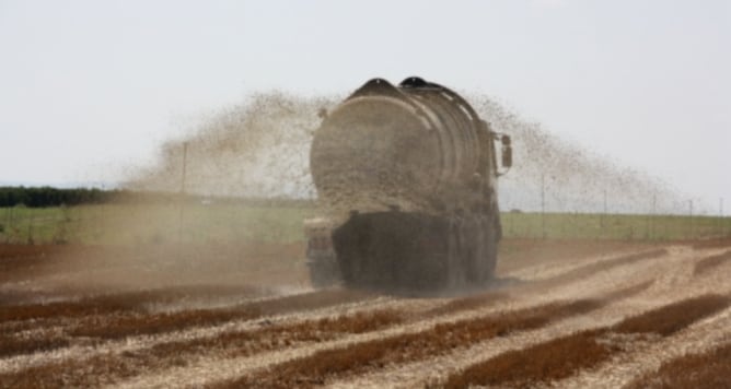 Un camió cisterna aplicant purins en un camp de cereal d'Alcarràs ja recol·lectat