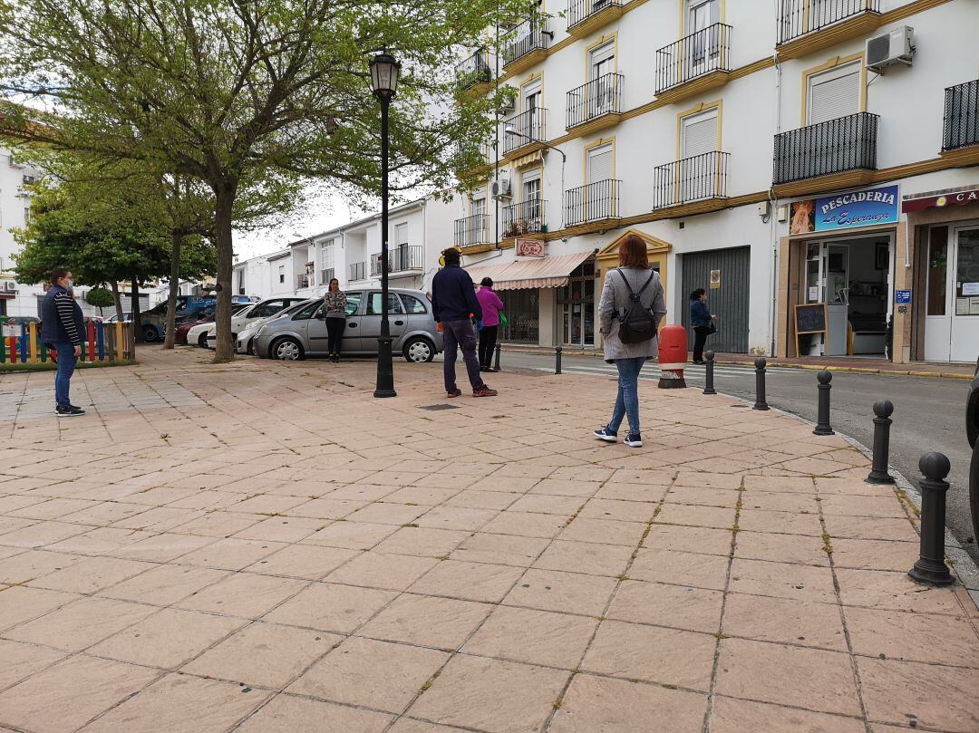 Varios vecinos esperan su turno para comprar en un comercio local