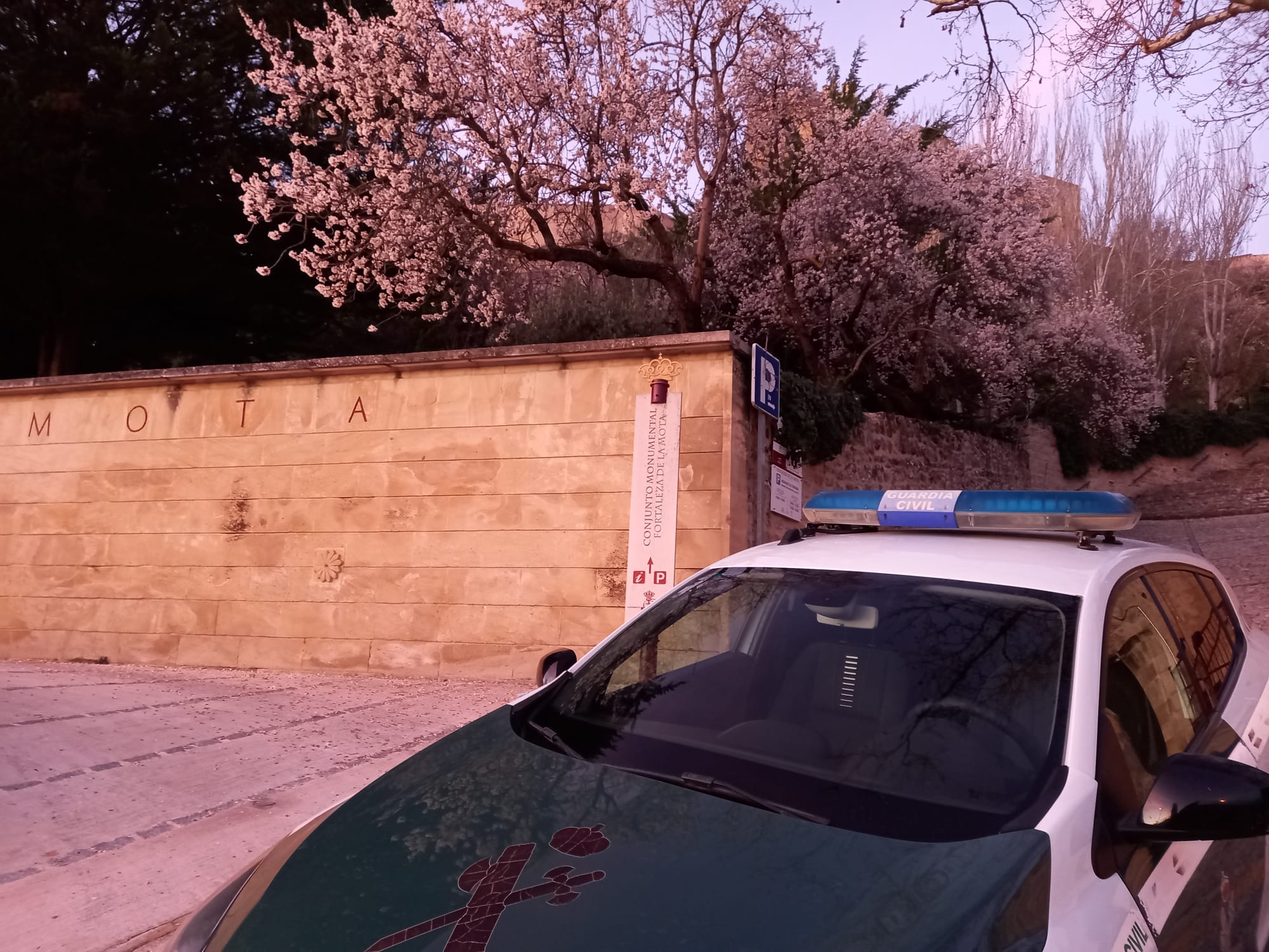 Un coche de la Guardia Civil aguarda a la entrada del Castillo de la Mota de Alcalá la Real