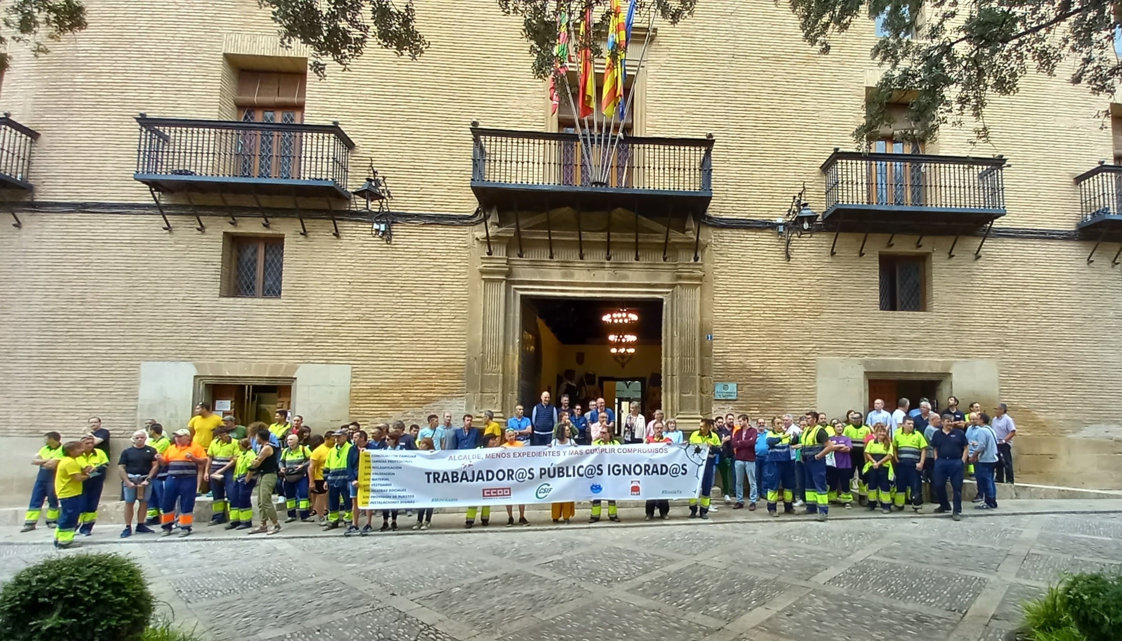 Trabajadores, a las puertas del Ayuntamiento de Huesca, mostrando su reivindicación