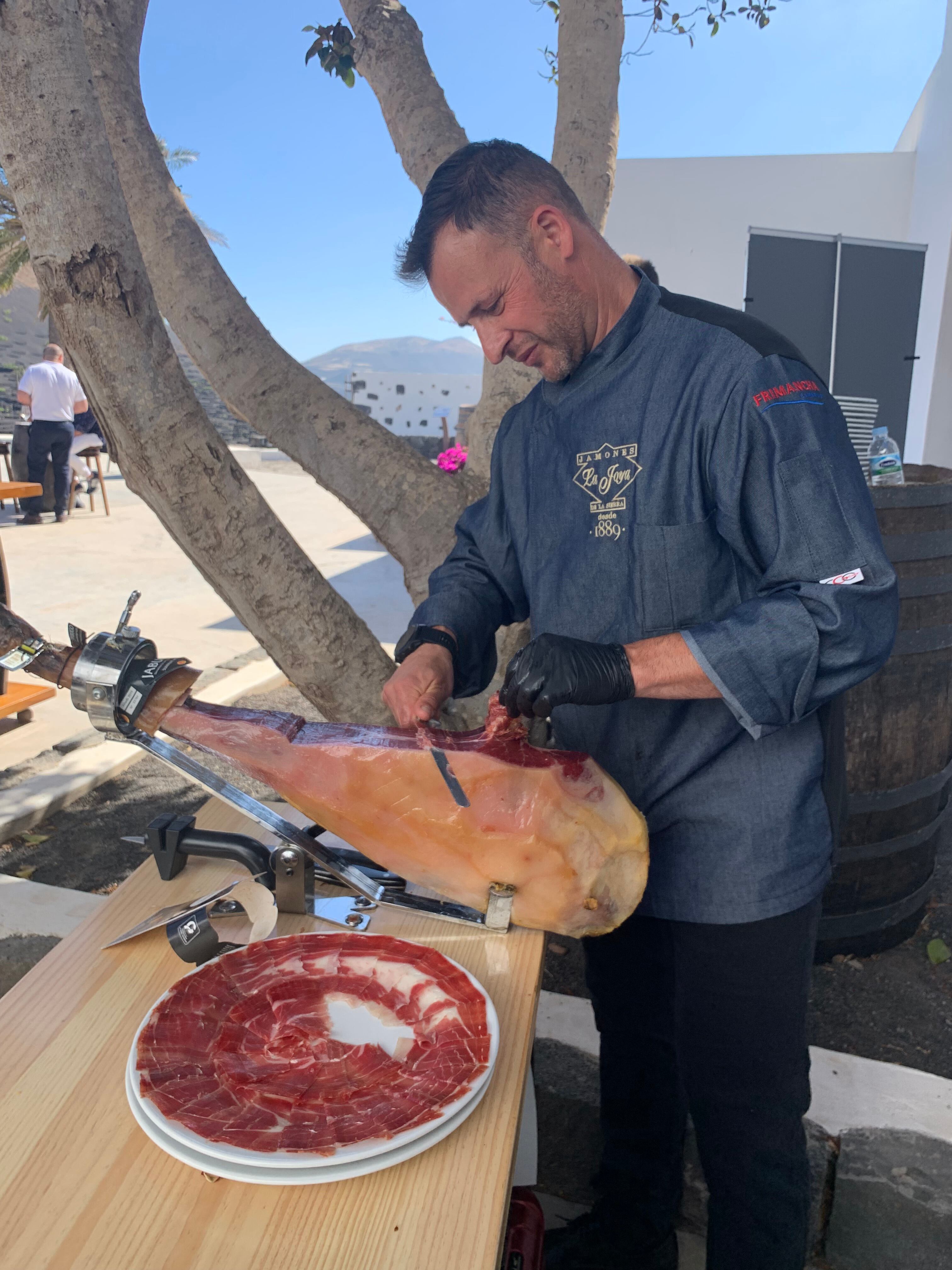 Marcos López cortando una pieza de jamón.