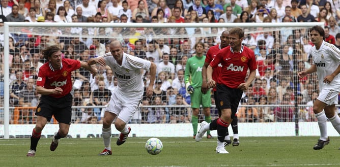 El centrocampista francés del Real Madrid Zinedine Zidane se lleva el balón ante los jugadores del Manchester United Jesper Blomqvist y Teddy Sheringham durante el partido &quot;Corazón Classic Match 2012, África en el alma&quot;, encuentro solidario que disputan j