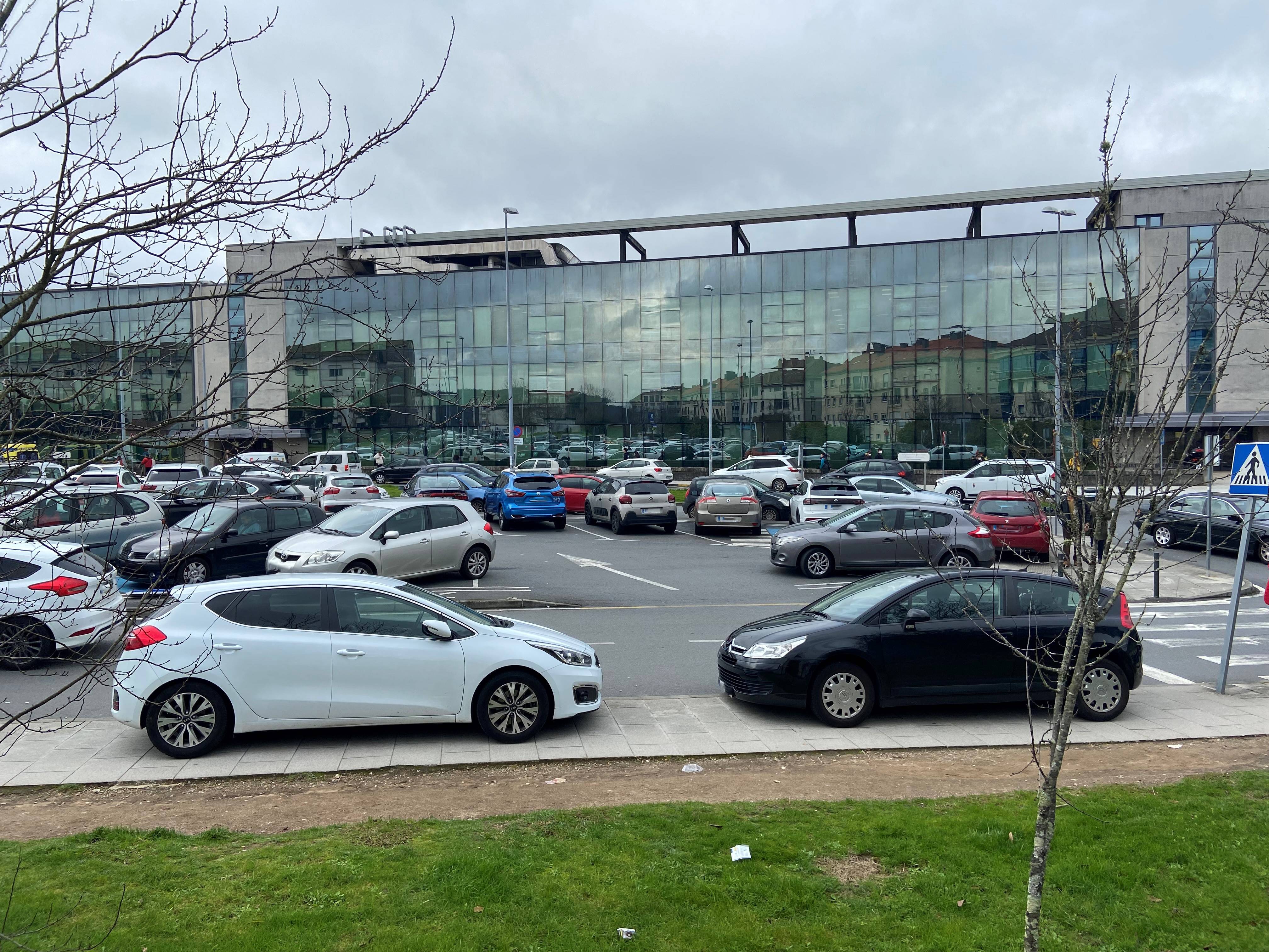 Coches mal aparcados, invadiendo las aceras, en la explanada del Hospital Clínico de Santiago de Compostela