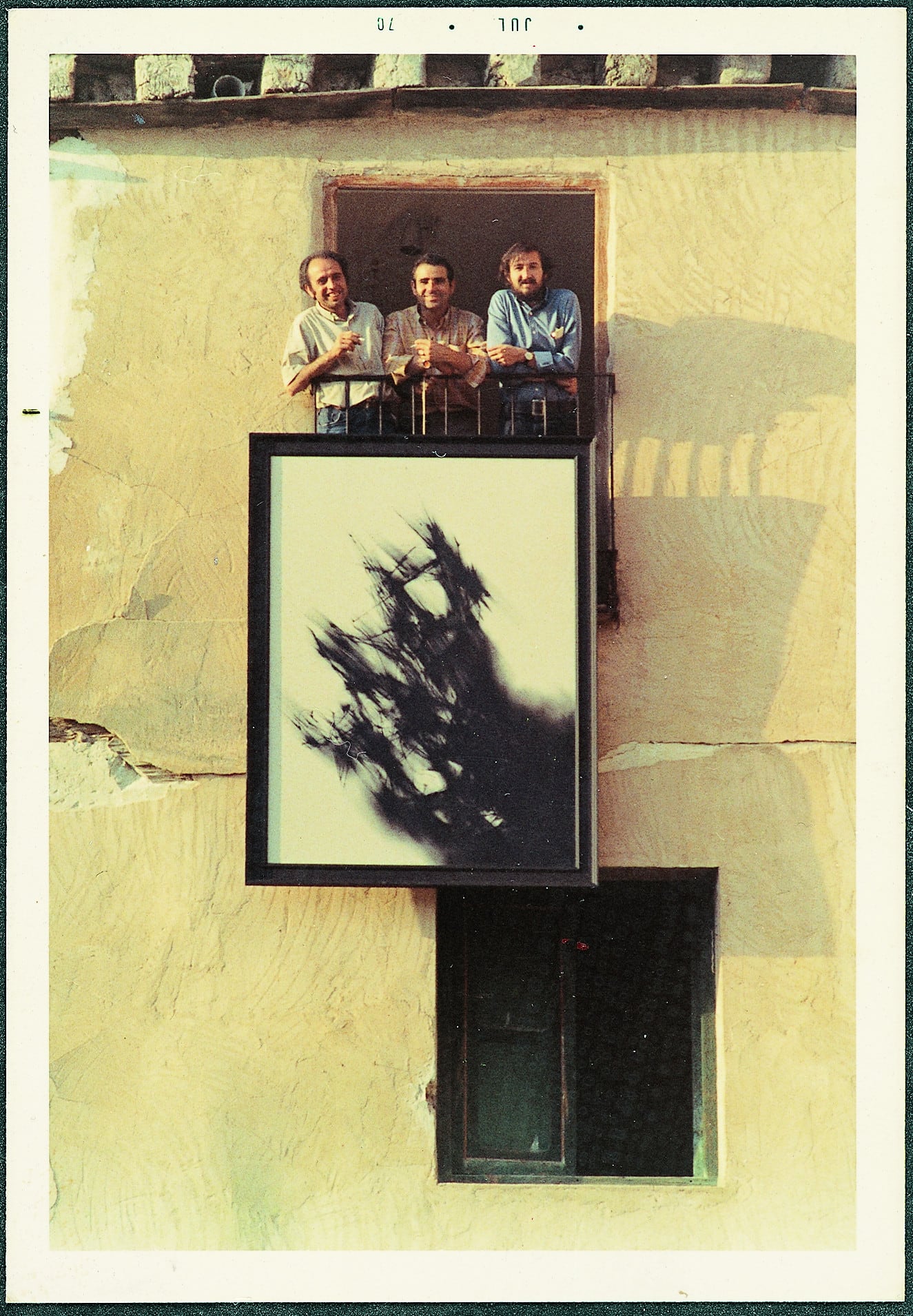 Luis Muro, Felipe Martín y Domingo Garrote descolgando un cuadro de Fernando Zóbel por el balcón de su casa, en la calle Pilares de Cuenca, 1979.