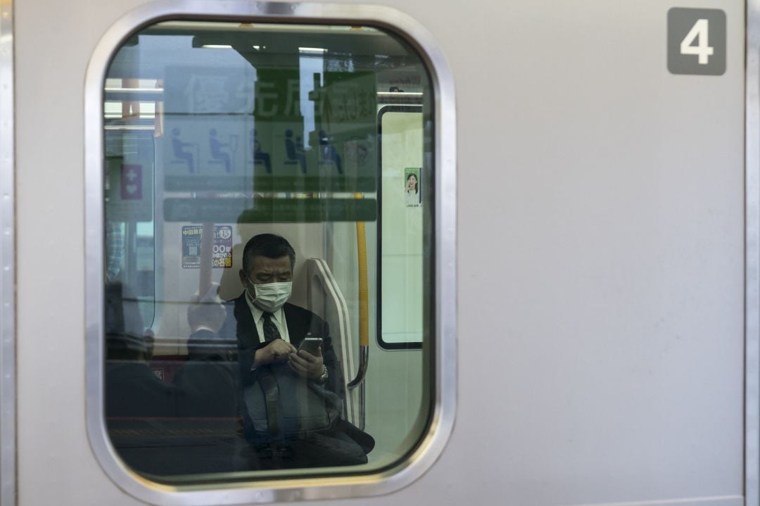 Un pasajero con su móvil en la estación japonesa de Shinjuku