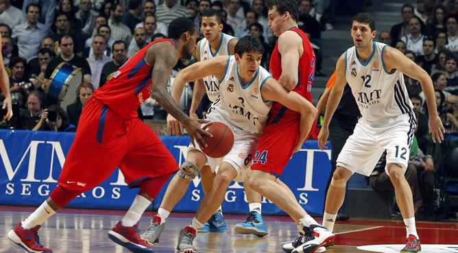 El alero del Real Madrid Carlos Suárez (c) y su compañero, Nikola Mirotic, ante el pívot del CSKA Moscú Sasha Kaun (2d), durante el partido correspondiente &#039;Top 16&#039; de la Euroliga de baloncesto