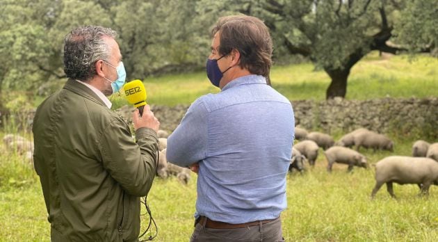 Rafael Delgado, de jamones Olalla, atiende en plena dehesa al micrófono de Paco García