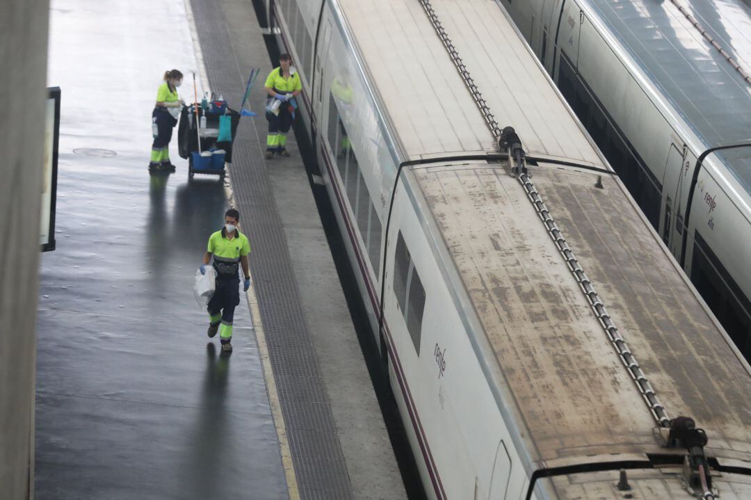 Varios trabajadores caminan por un andén en la estación de Atocha