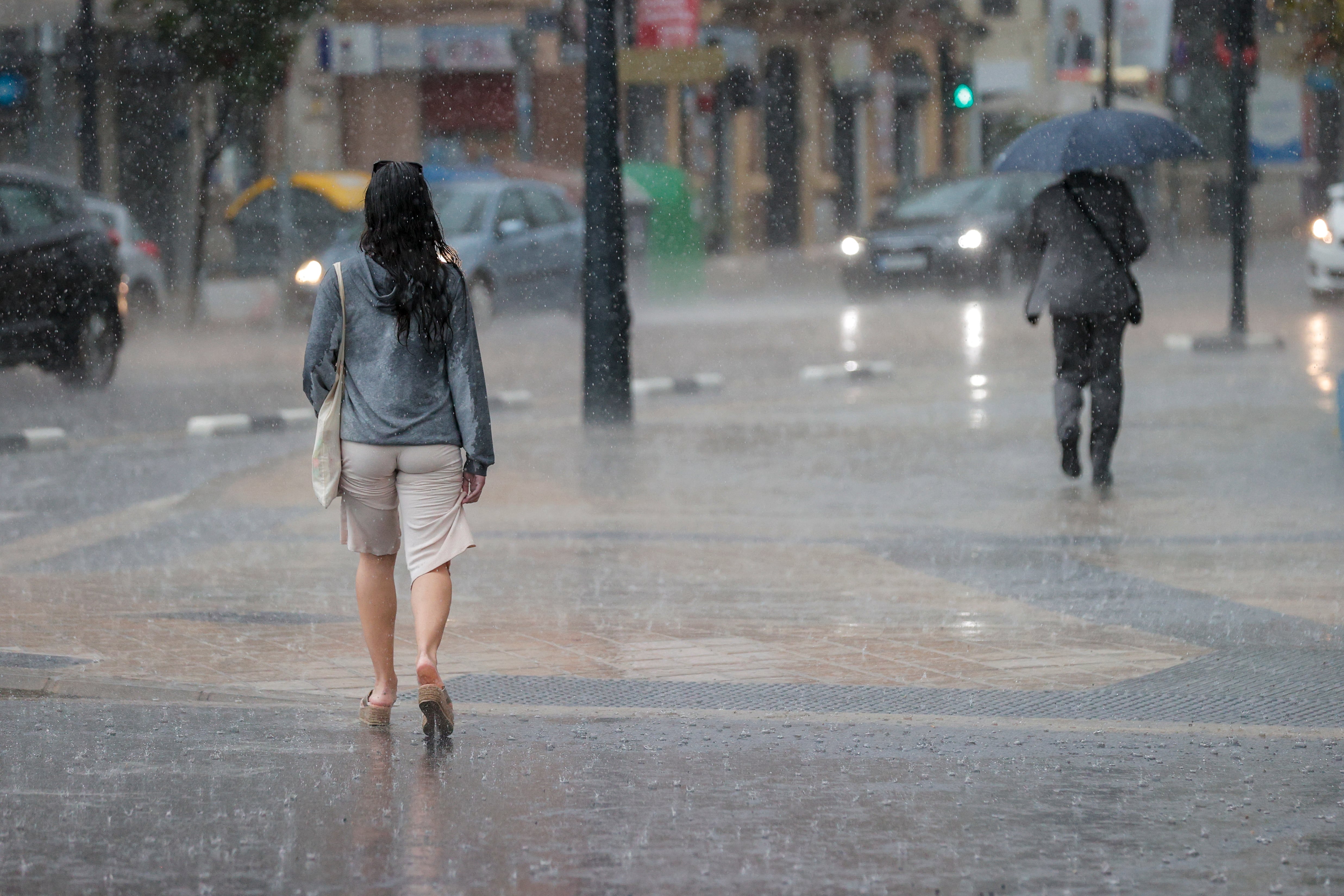 Dos personas pasean bajo la lluvia durante la tarde de este lunes en la Comunidad Valenciana