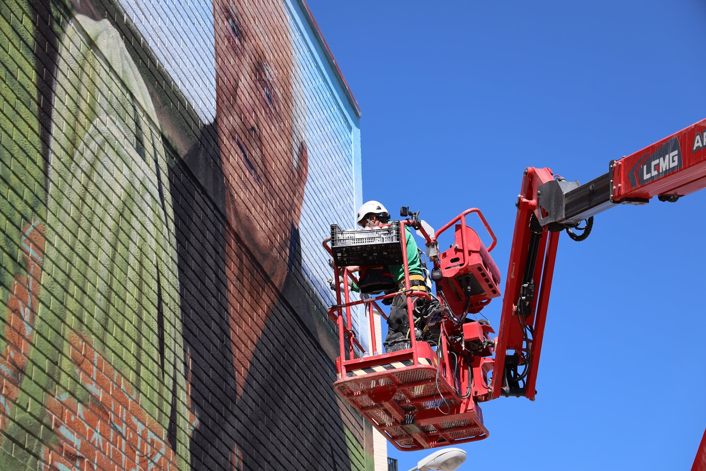 Christian Sasa trabaja en el nuevo mural de Fuenlabrada, 'Manos de Acero', un homenaje a la acelga y la agricultura de la localidad