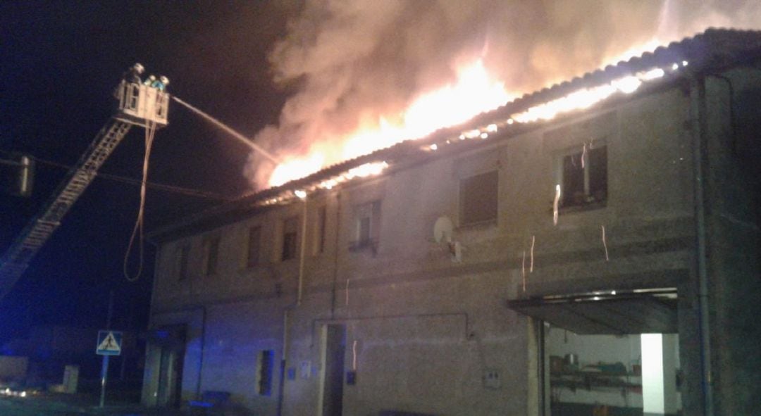 Los bomberos tratan de sofocar el incendio de las casas