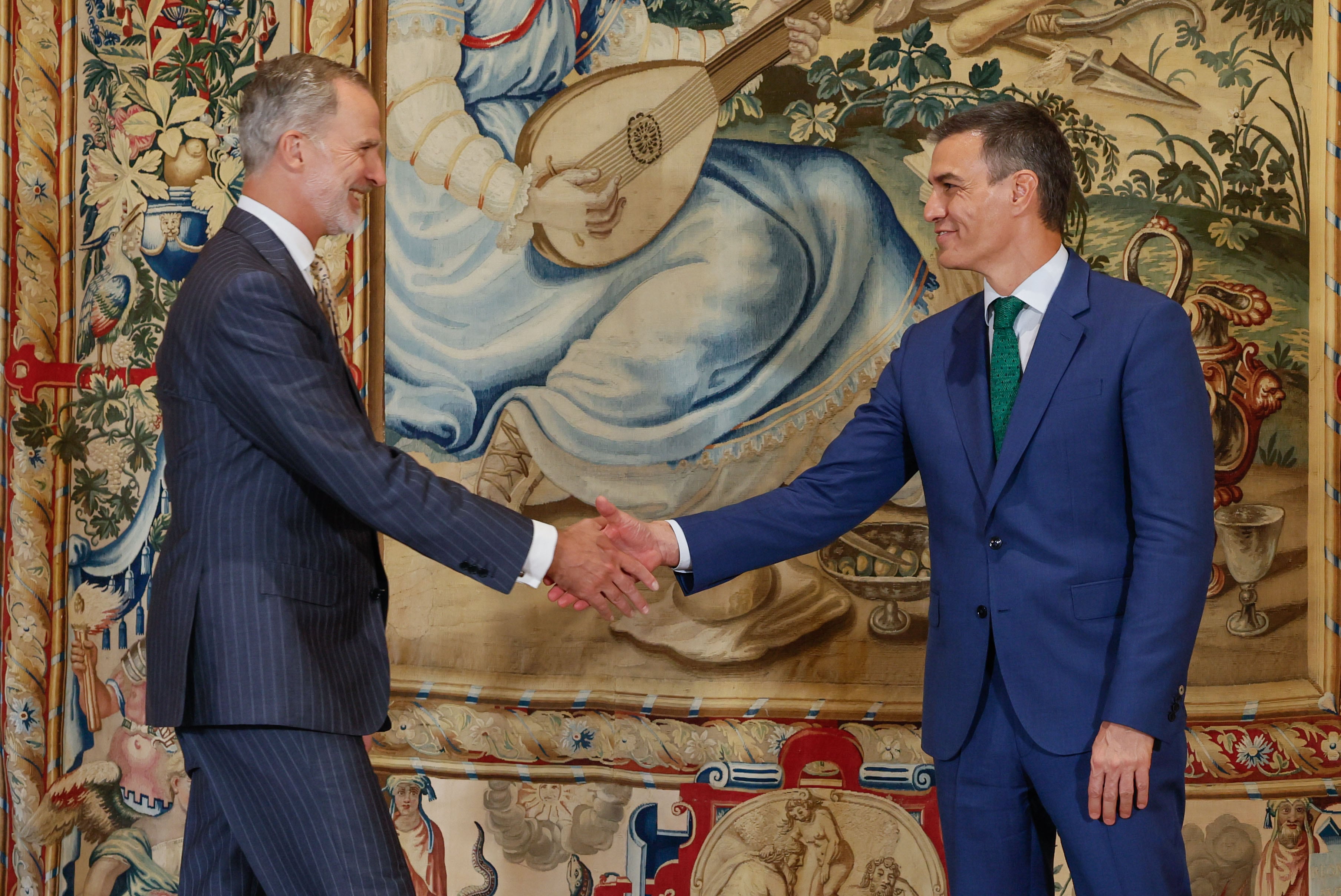 El rey Felipe VI saluda al presidente del Gobierno, Pedro Sánchez (d), antes de la reunión que han mantenido en el Palacio de la Almudaina, en Palma