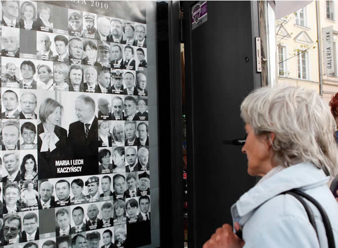 Una mujer mira en Varsovia la fotografía del último presidente de Polonia, Leck Kaczynski, acompañado por su esposa