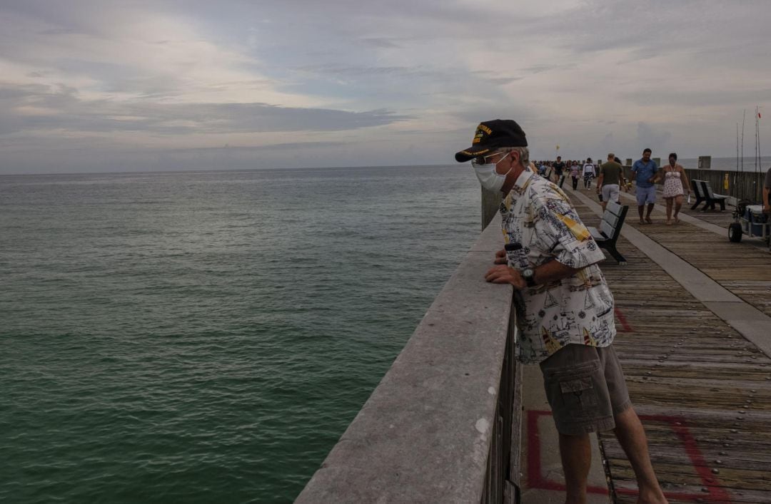 Un hombre observa el mar en el paseo marítimo de Pensacola, Florida.