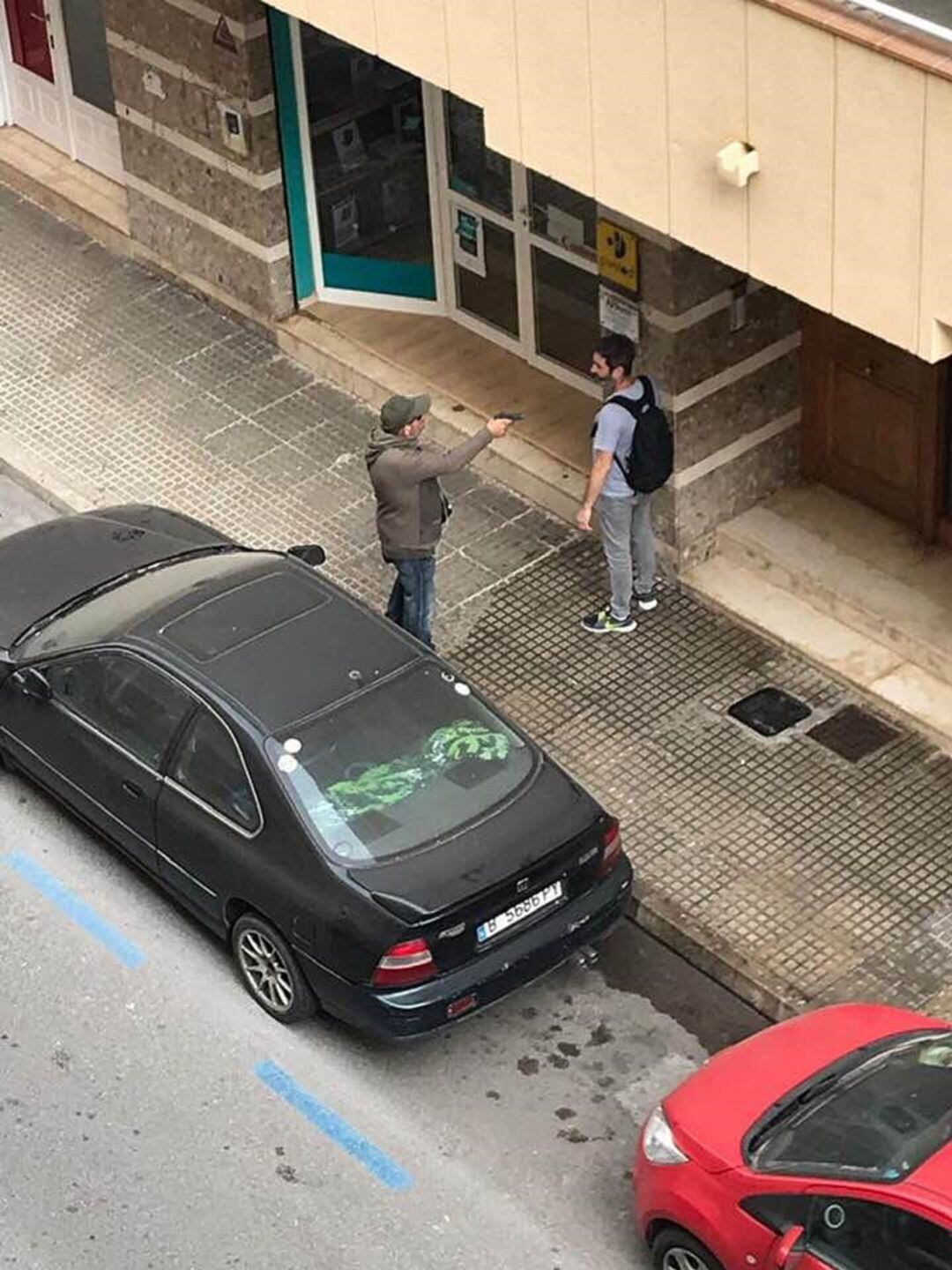 El atracador amenazó a los transeúntes con el arma de fogueo. 