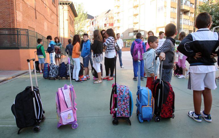 Varios niños esperan a la entrada de un colegio