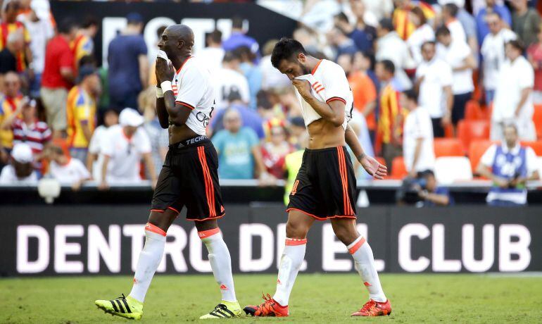 GRA221. VALENCIA, -Los jugadores del Valencia,el francés Eliaquim Mangala y el argentino Ezequiel Garay (d), se retiran del terreno de juego tras el partido de liga que han disputado esta tarde contra el Betis en el estadio de Mestalla. EFE, Kai Försterli