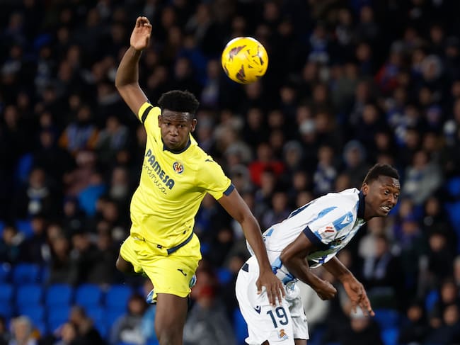 SAN SEBASTIÁN, 23/02/2024.- El defensa del Villarreal Yerson Mosquera (i) cabecea un balón ante Sadiq Umar, de la Real Sociedad, durante el partido de Liga que Real Sociedad y Villarreal CF disputan este viernes en el Reale Arena, en San Sebastián. EFE/Juan Herrero