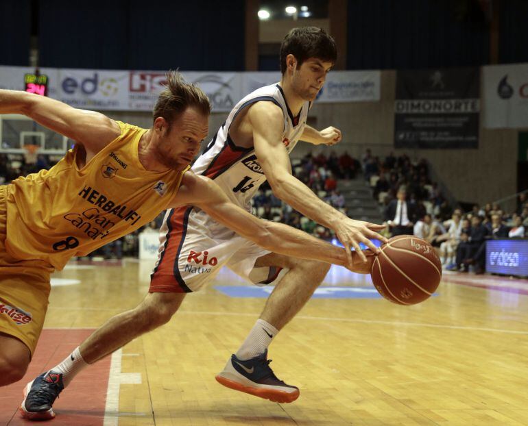 El jugador del Rio Natura Obradoiro, Santi Yusta (d), disputa el balón con el alero australiano del Herbalife Gran Canaria, Brad Newley, durante el partido de liga ACB de baloncesto disputado en el pabellón multiúsos de Sar en Santiago de Compostela