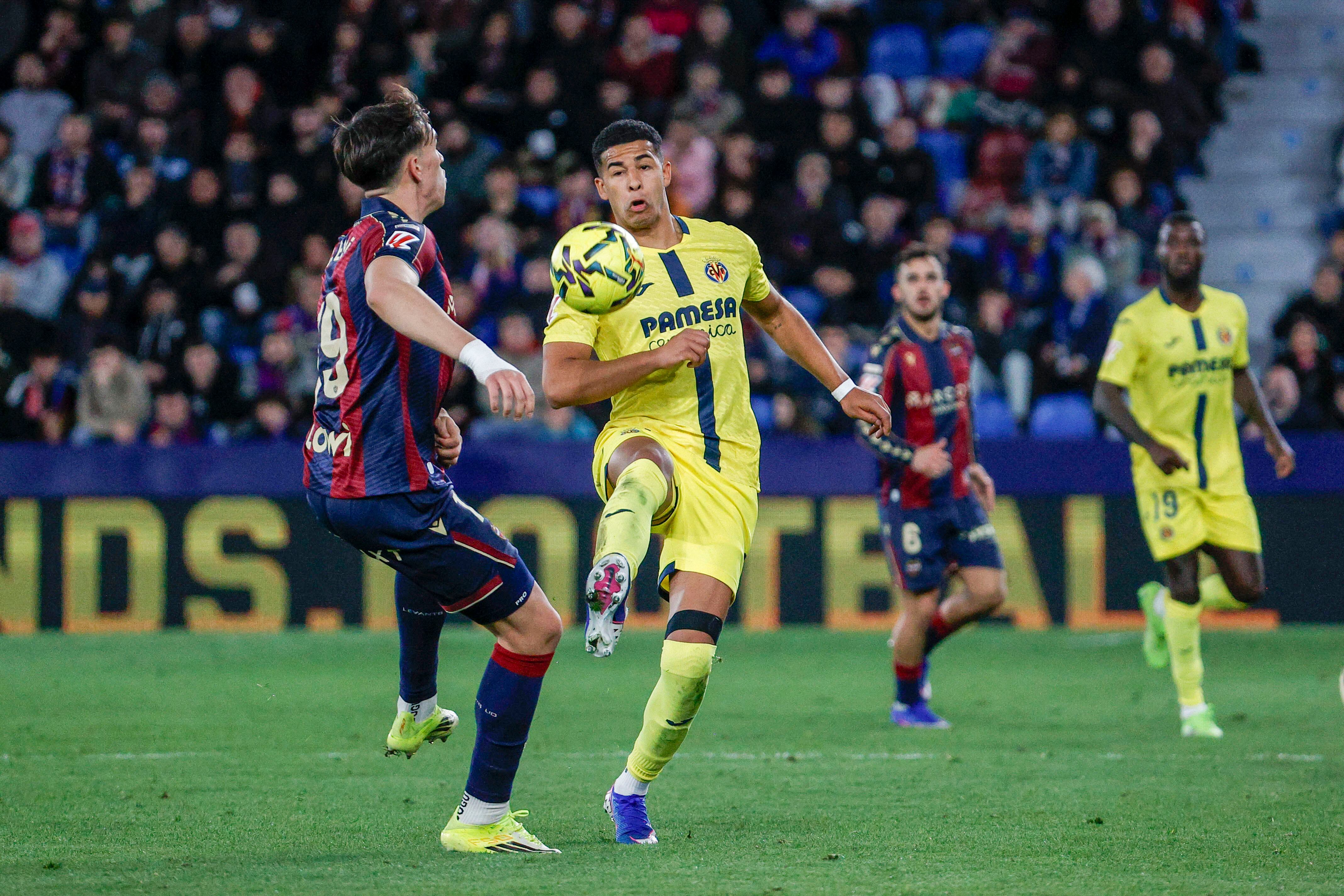 VALENCIA, 18/02/2026.- El delantero del Levante, Carlos Espí (i), disputa el balón ante el defensa uruguayo del Villarreal, Santiago Mouriño, durante el encuentro correspondiente a la jornada 16 de Laliga EA Sports que Levante y Villarreal disputan este miércoles en el estadio Ciutat de Valencia. EFE / Manuel Bruque.