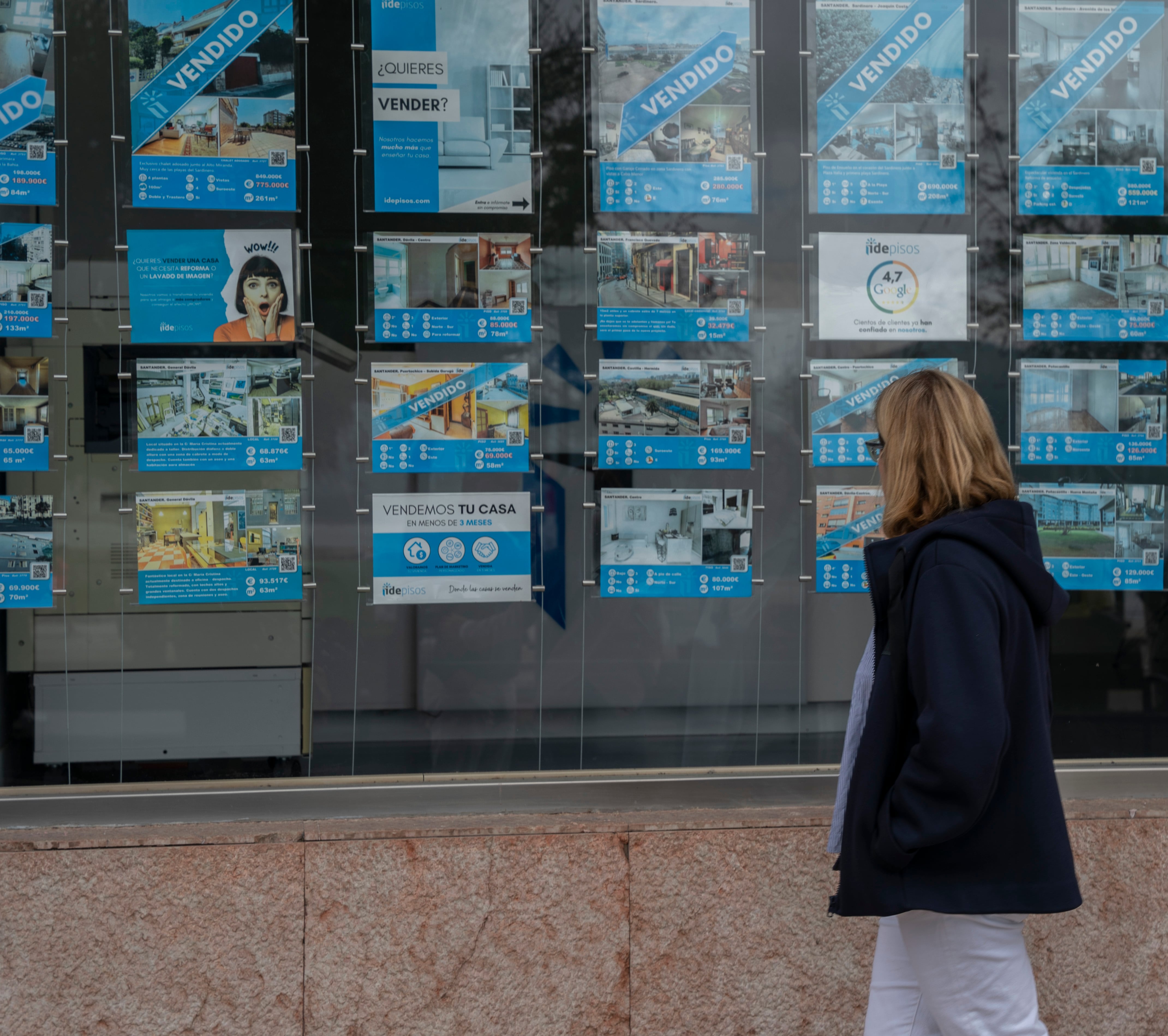 SANTANDER, 27/05/2022.- Una mujer observa el escaparate de una inmobiliaria este viernes en Santander. Las hipotecas constituidas sobre viviendas en España sumaron 43.378 el pasado marzo, el 18 % por encima del mismo mes de 2021, con lo que acumularon trece meses consecutivos al alza, según datos publicados este viernes por el Instituto Nacional de Estadística (INE). El importe medio de las hipotecas firmadas sobre vivienda se situó en 145.715 euros, un 6,5 % más que un año antes, y el capital prestado alcanzó los 6.321 millones de euros, el 25,6 % superior a marzo de 2021. EFE/ Román G. Aguilera
