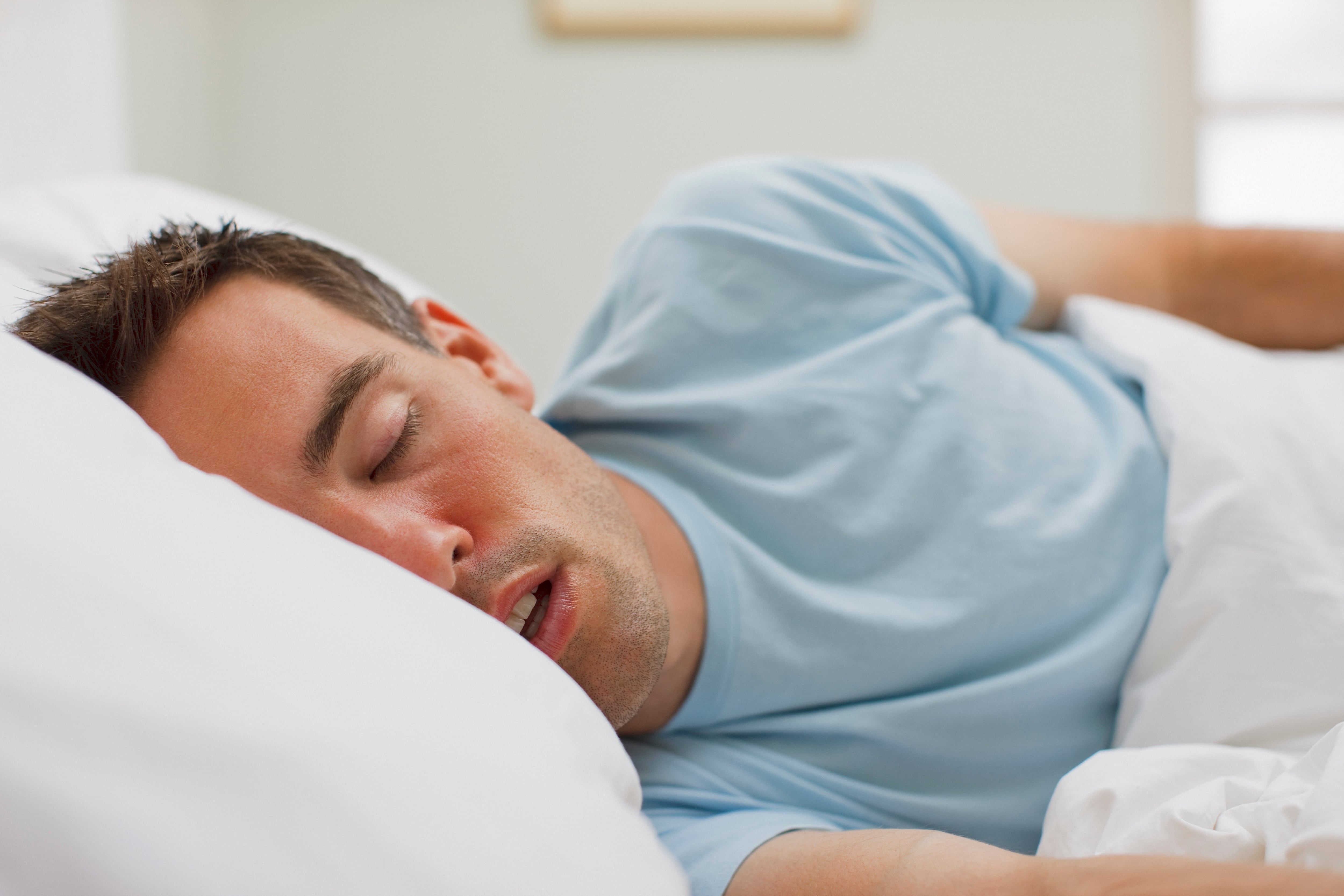 Un hombre durmiendo sobre la cama.