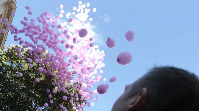 Un participante en la suelta de 1.000 globos rosas este sábado en Bilbao con motivo del Día Mundial contra el Cáncer de Mama, que se celebrará mañana.