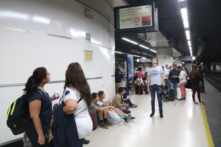 Passatgers esperen el tren de Rodalies i miren les pantalles on s'informa de la vaga, el passat octubre.