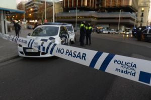 Spanish policemen stand at the entrance of Genova street close to the Spanish Popular Party&#039;s headquarters after a man runned his car with two gas cylinders into the political party&#039;s building, in Madrid on December 19, 2014. The area in central Madrid wa