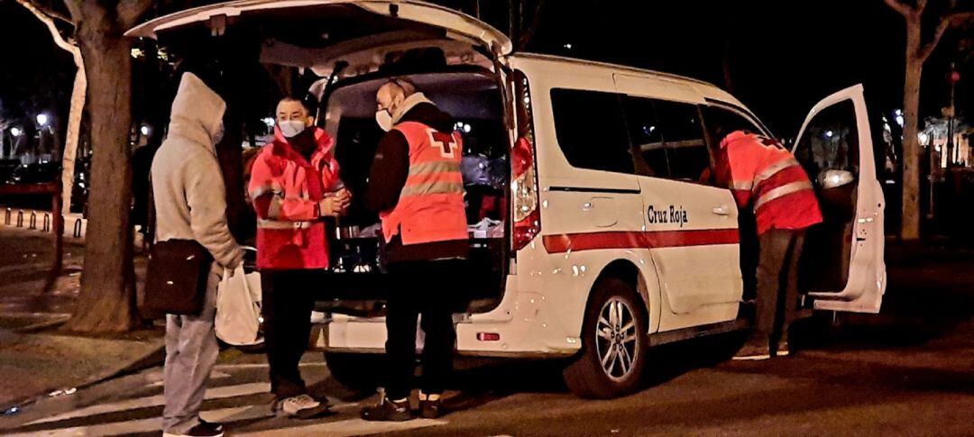 Los voluntarios de Cruz Roja, durante el reparto nocturno  de comida, mantas y bebida caliente a sin techos por las calles de Zaragoza