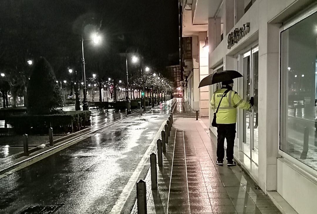 Un sereno comprueba que un comercio está bien cerrado durante la ronda nocturna.