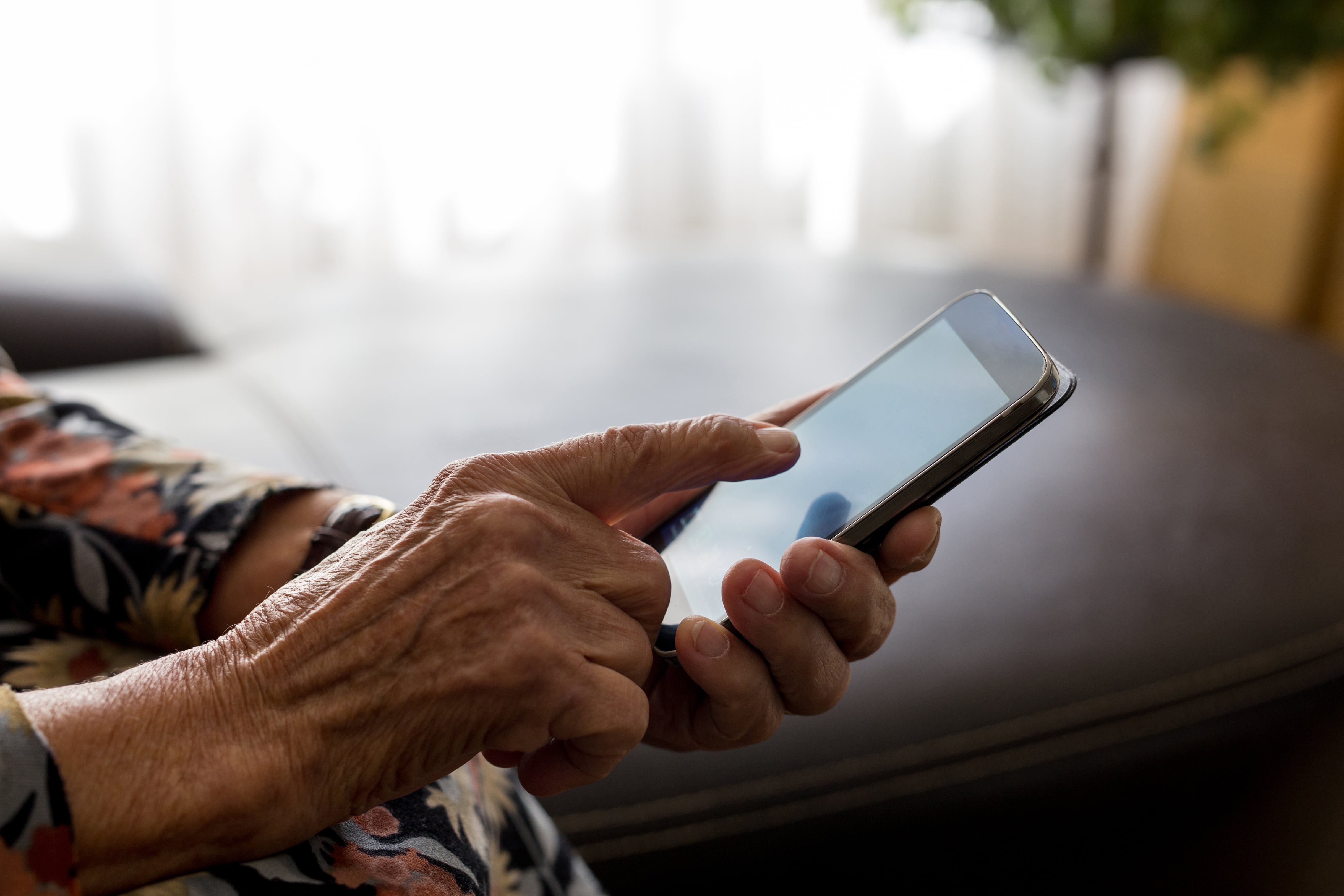 Una mujer mayor usa su teléfono móvil