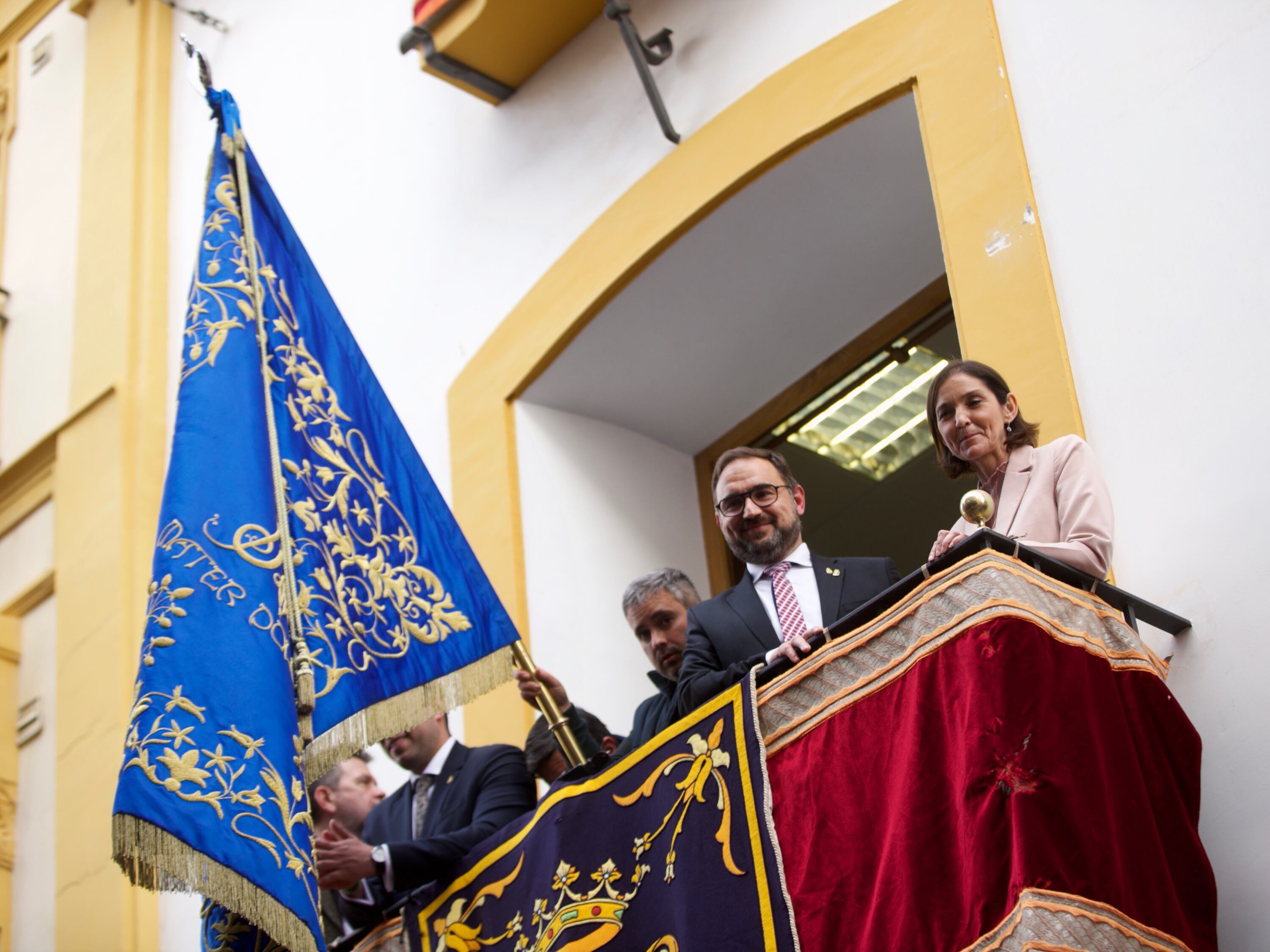 MURCIA, 15/04/2022.-El alcalde de Murcia, Diego José Mateos y la ministra de Turismo, Reyes Maroto, en el balcón de la Comunidad de Regantes en la Calle Corredera de Lorca (Murcia), asisten a la tradicional recogida de banderas previa a la procesión de Viernes Santo. EFE/Juan Carlos Caval