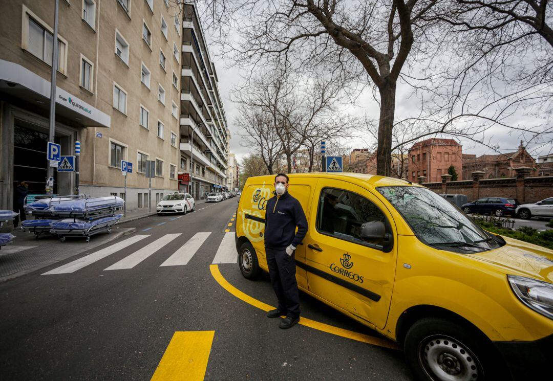 Un repartidor de Correos al lado de su vehículo de trabajo tras recoger unas pizzas cocinadas en la pizzería Grosso Napoletano ubicada en la calle Sánchez Pacheco, 69 (Madrid) para llevarlas expresamente al personal de los centros sanitarios de Madrid. Esta labor surge tras la unión de la empresa de mensajería con #Food4Heroes, una iniciativa solidaria surgida de los restauradores madrileños para proporcionar la comida y la cena al personal de los principales centros sanitario de la capital, en Madrid (España), a 27 de marzo de 2020.