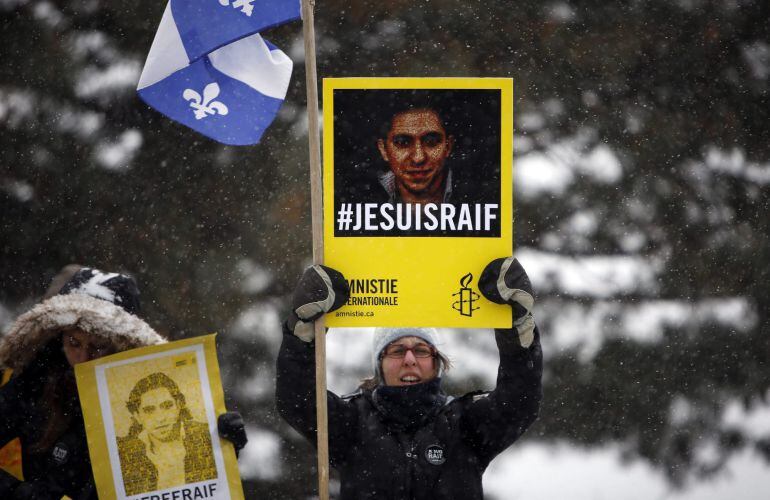 CBX11 OTTAWA (CANADÁ), 29/10/2015.- Fotografía de archivo fechada el 29 de enero de 2015 que muestra a una mujer que sostiene una pancarta con la imagen del bloguero saudí Raif Badawi durante una marcha hacia el Parlamento en Ottawa, Canadá. Badawi result