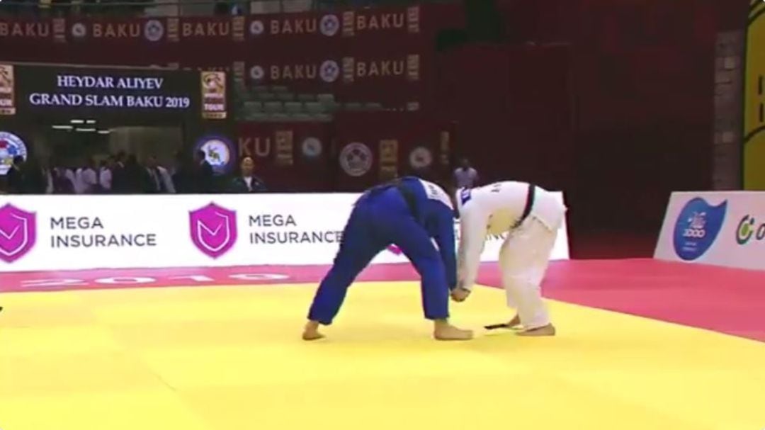 En cuanto ambos judokas entran en contacto, el móvil se cae desde el interior del judogi al tatami.