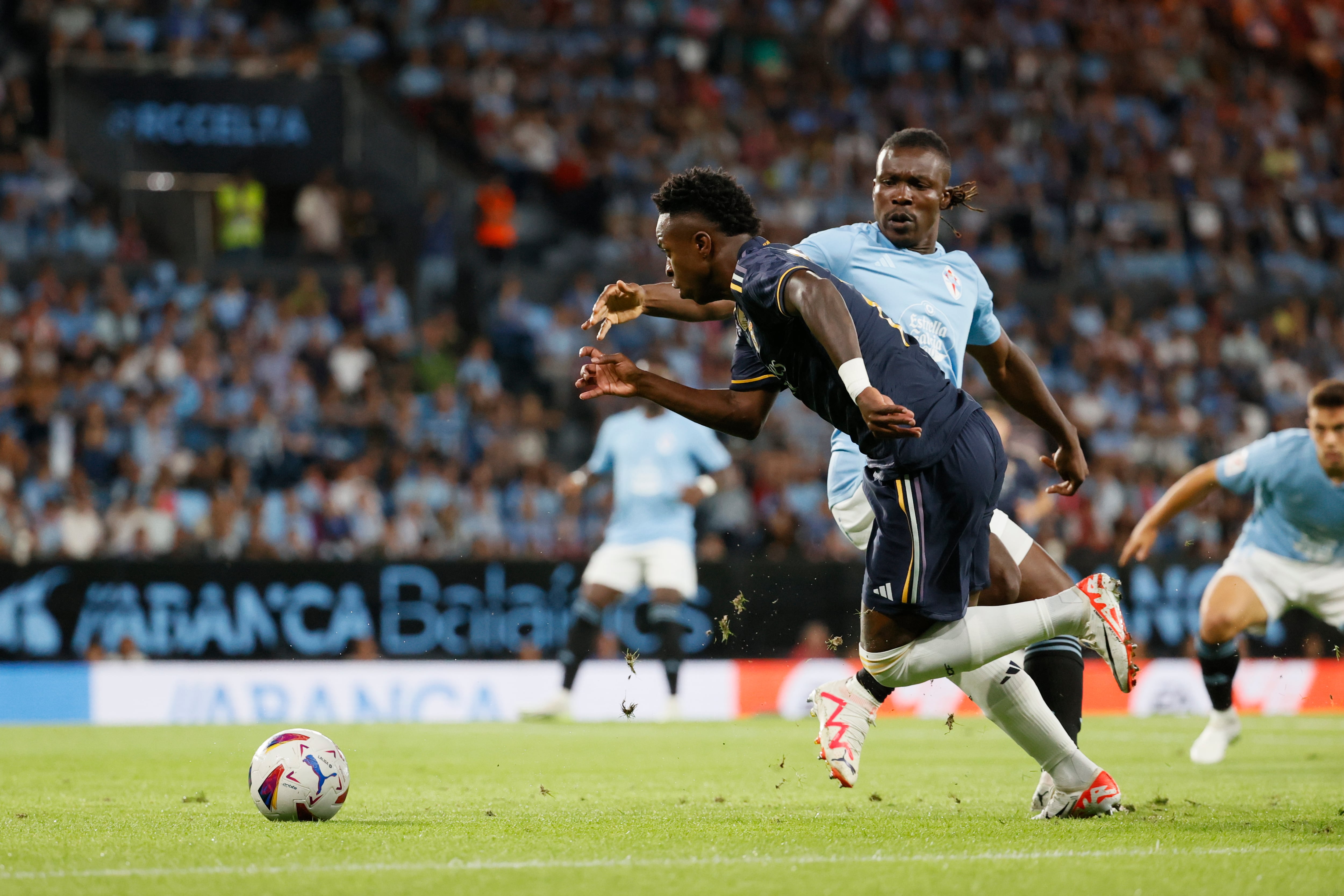 VIGO (GALICIA), 25/08/2023.- El delantero brasileño del Real Madrid Vinícius Júnior (i) disputa una posesión ante Joseph Aidoo, defensa ghanés del Celta de Vigo durante el partido correspondiente a la Jornada 3 de LaLiga que enfrenta este viernes al Celta de Vigo y Real Madrid en el Estadio de Abanca Balaídos (Vigo). EFE/ Lavandeira
