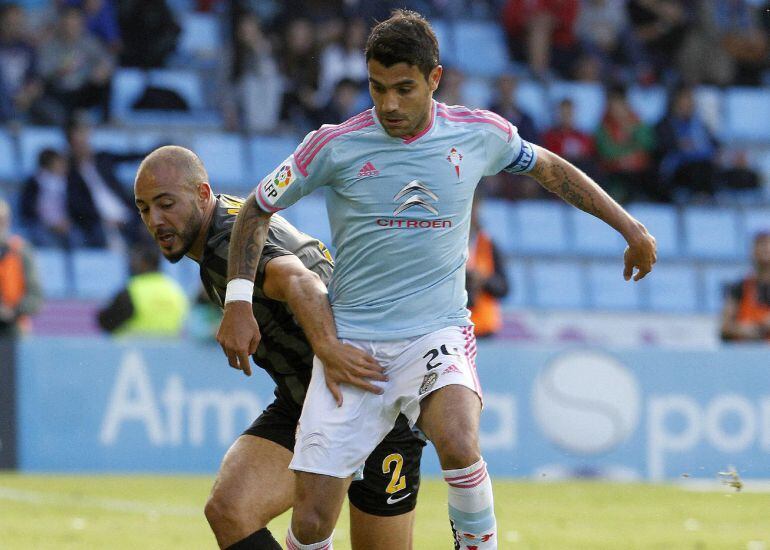 Augusto Fernández disputa el balón ante el delantero marroquí del Málaga, Nordin Amrabat