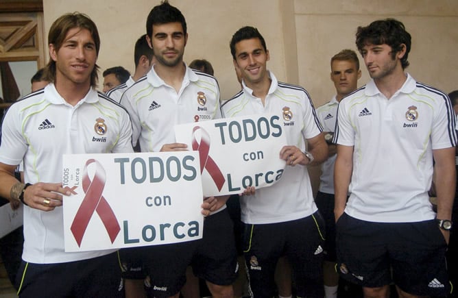 Los jugadores del Real Madrid Sergio Ramos, Raúl Albiol, Álvaro Arbeloa y Esteban Granero posan con una pancarta de apoyo a Lorca durante la visita que la plantilla madridista ha realizado a esta localidad para solidarizarse con los ciudadanos tras los do