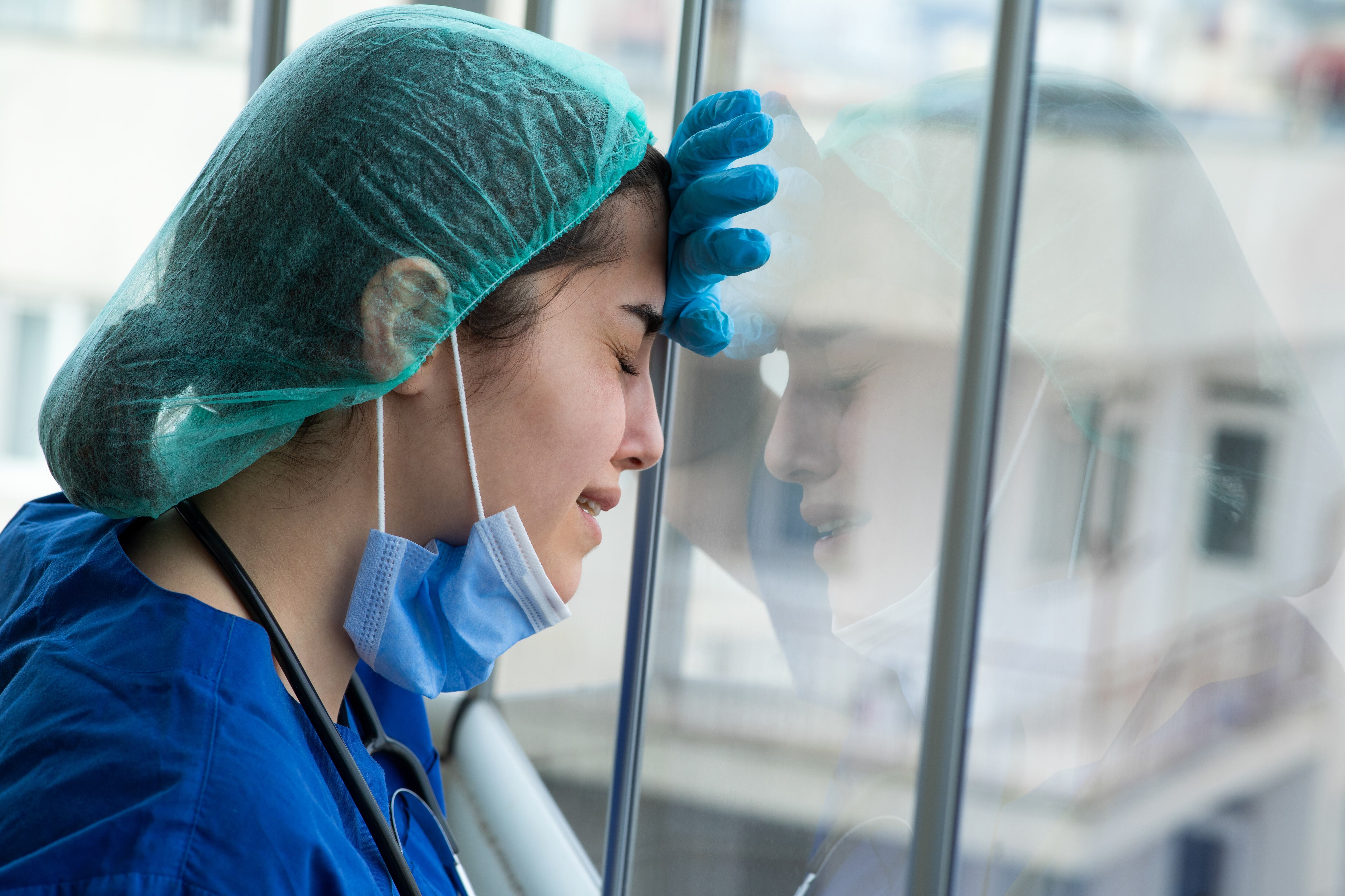 Una enfermera estalla y llora posada en una ventana de un hospital por la presión