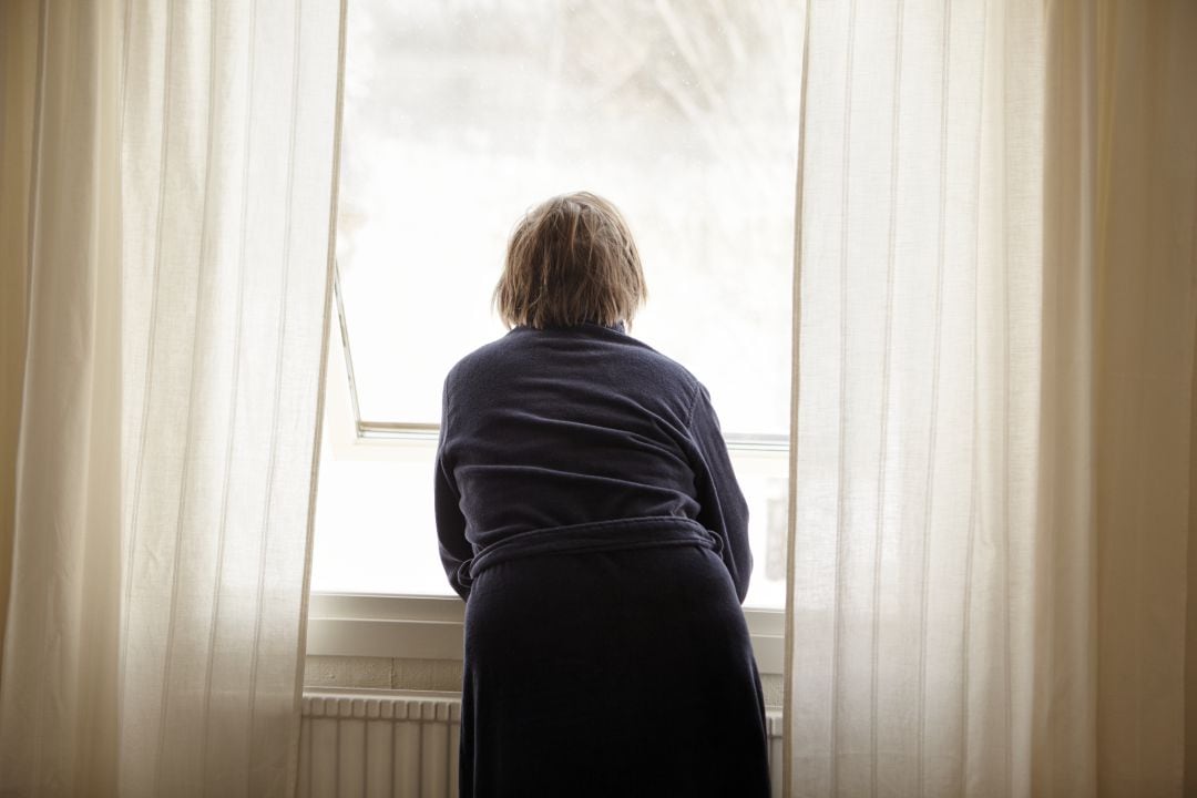 Una mujer mira por la ventana