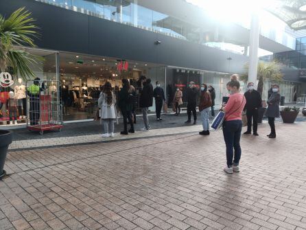 Colas minutos antes de la apertura de algunos comercios.