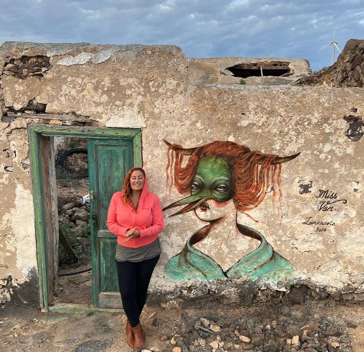 La artista @vanessa_alice junto a la pintura realizada en una casa abandonada de Lanzarote.