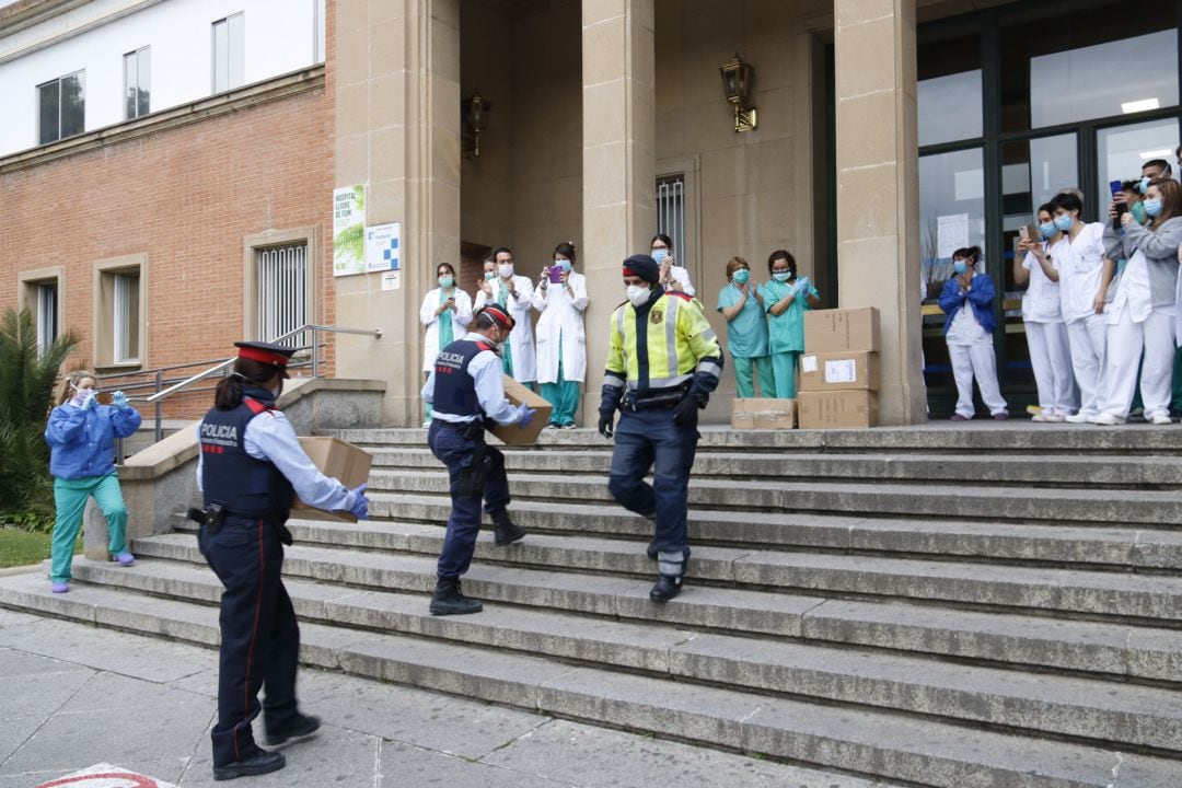 Diversos agents dels Mossos d'Esquadra portant material sanitari als treballadors del Trueta que diversos ciutadans han donat 
